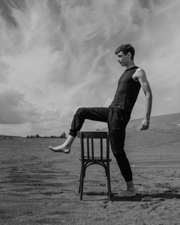 Man jumping over chair in desert. black and whiteの写真素材