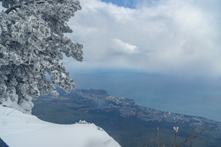 Picturesque view of the city of Yalta and Black Sea covered snow top of Crimea Ai Petri mountain in springの写真素材
