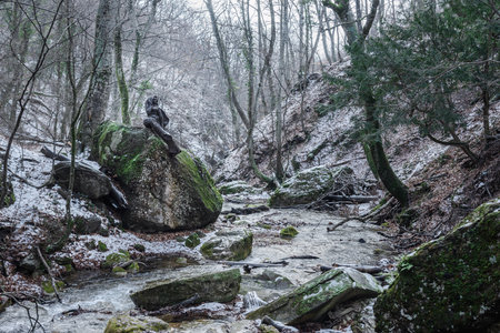 Mermaid statue on stone on the river near the waterfall Djur-Djur in early spring with snow. Crimeaの写真素材