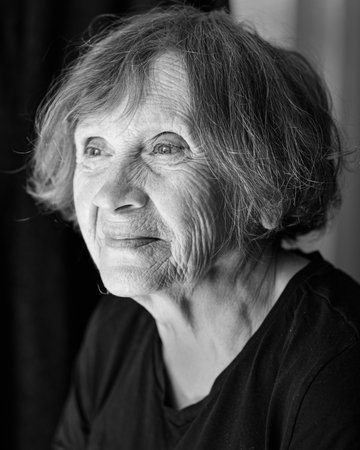 Portrait of senior smiling caucasian woman on black backgroundの写真素材