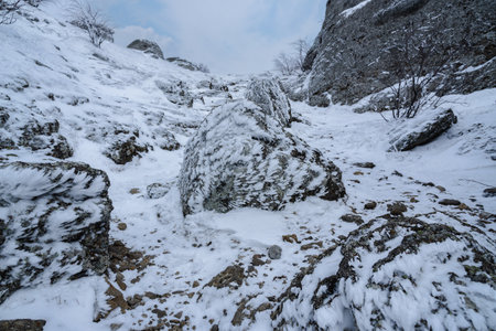 Trail between rocks with snow and ice to Mount Alenga near Southern Demerdzhi in snow and ice in early spring. Crimeaの写真素材