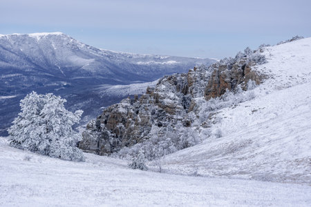 Rocks on Southern Demerdzhi mountain in snow after blizzard in early spring. And view of Chatyr-Dag. Crimeaの写真素材