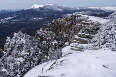 Rocks on Southern Demerdzhi mountain in snow after blizzard in early spring. And view of Chatyr-Dag. Crimeaの写真素材