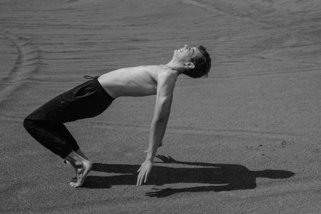 Man lying down on sand in desertの写真素材