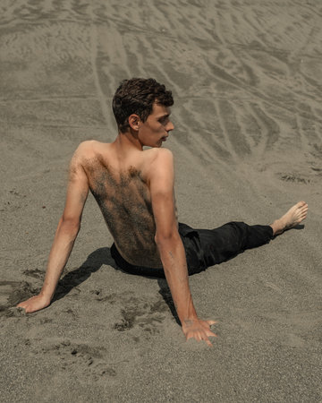 Lone man sitting on the sand in sandy desertの写真素材
