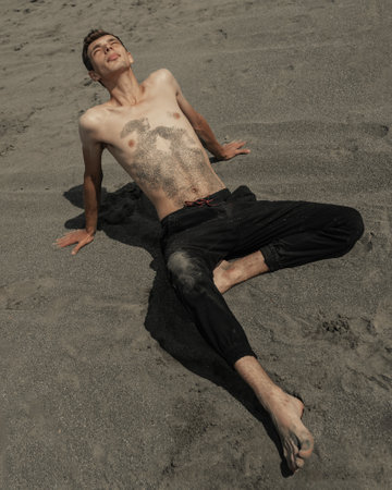 Man sitting on the sand in sandy desertの写真素材