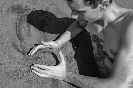 Man's hands and sand in desert. black and whiteの写真素材