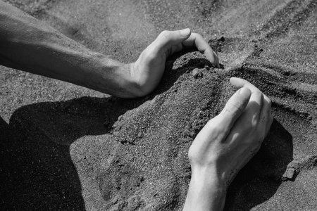 Man's hands and sand in desert. black and whiteの写真素材