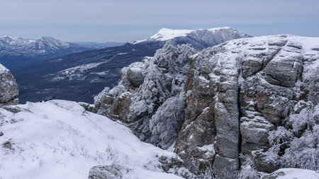 Rocks on Southern Demerdzhi mountain in snow after blizzard in early spring. And view of Chatyr-Dag. Crimeaの写真素材