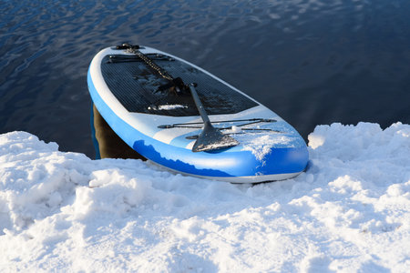 SUP board in snow and water in winter. Winter season and active leisure conceptの写真素材