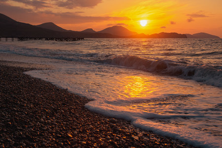 Closeup sea beach and orange sunrise sky calmness in springの写真素材