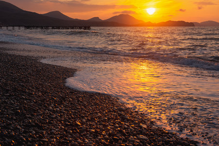 Closeup sea beach and orange sunrise sky calmness in springの写真素材
