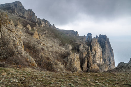 Rocks in Dead city in fog and clouds. Khoba-Tele Ridge of Karadag Reserve in early spring. Crimeaの写真素材