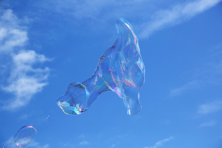Soap bubbles against the blue sky with white cloudsの写真素材