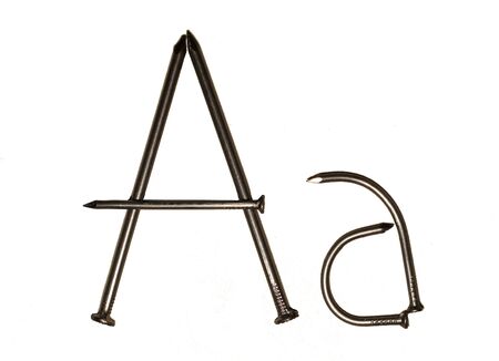 Uppercase and lowercase letters "A a" laid out of iron nails on a white backgroundの写真素材