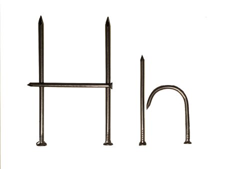 Uppercase and lowercase letters "H h" made of iron nails on whiteの写真素材