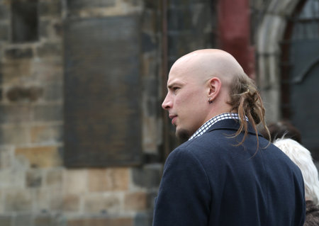 Portrait of a man with a small beard, shaved head and a bun of hair on the back of his head.のeditorial素材