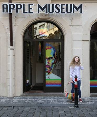 A young blonde girl with a basket in LGBT colors stands at the entrance to the Apple Museumのeditorial素材