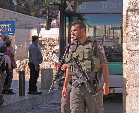 Two armed Israel Defense Forces soldiers maintain order in Jerusalemのeditorial素材