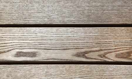 Three wooden boards arranged horizontally with a pronounced textureの写真素材