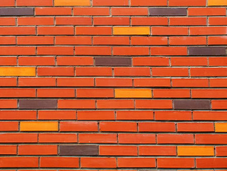 A fragment of a wall made of facing bricks of red color with a small amount of brown and yellow.の写真素材