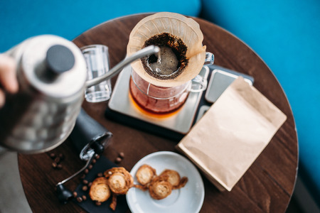 Hand drip coffee, barista pouring water on coffee ground with filter. Simple set for manual brewing.の写真素材