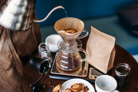 Hand drip coffee kit, barista pouring water on coffee ground with filter.の写真素材