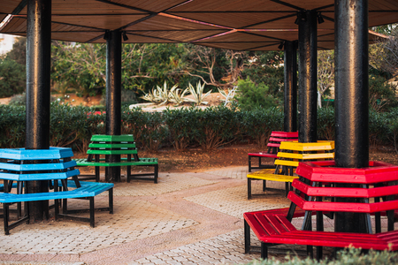 Park colored benches located around the column. Blue, yellow, green and redの写真素材