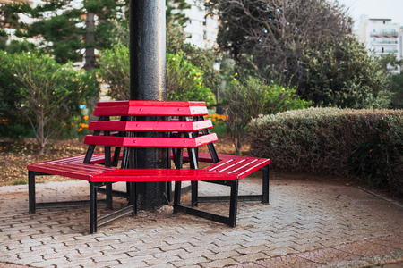 Red bench located around the column in public parkの写真素材