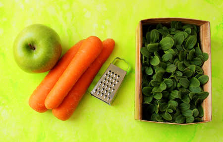 Healthy food from carrots, apples with a box of fresh herbs.の写真素材