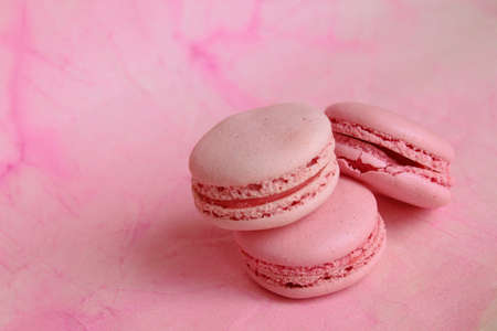 Three pink macaroon cakes on a pink background. Bright pink background.の写真素材