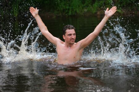 Young man divorces hands in hand and jumps from the wateの写真素材