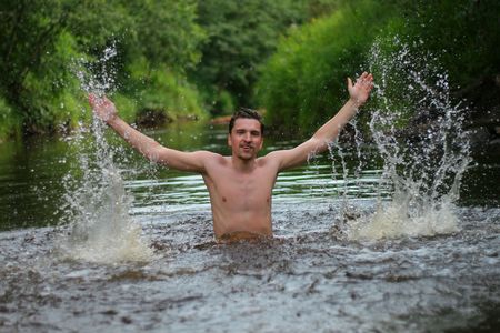 Young man divorces hands in hand and jumps from the wateの写真素材
