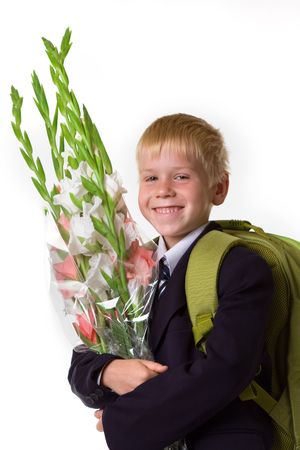 schoolboy with flowers and a large backpackの写真素材