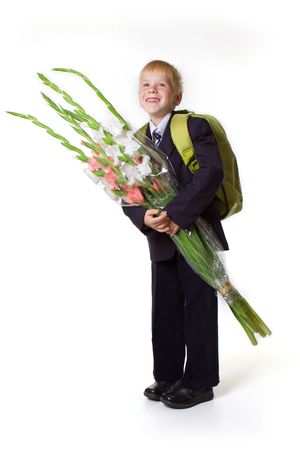 Schoolboy with flowers and a large backpackの写真素材