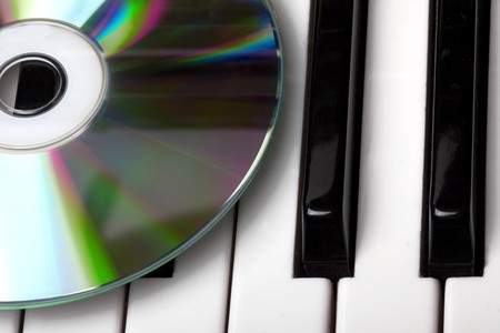 Image of the cd-drive, lying on the piano keysの写真素材