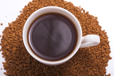 Picture of a cup of coffee, which is next to the dispersal of coffeeの写真素材