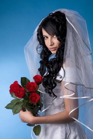 Image of the brunette bride with red roses on a blue backgroundの写真素材