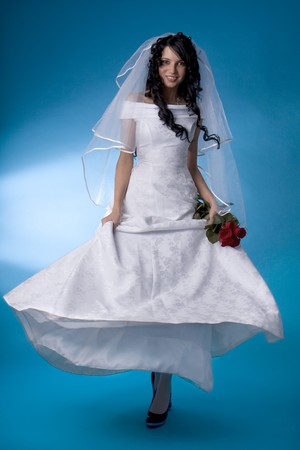 Image of the brunette bride with red roses on a blue backgroundの写真素材