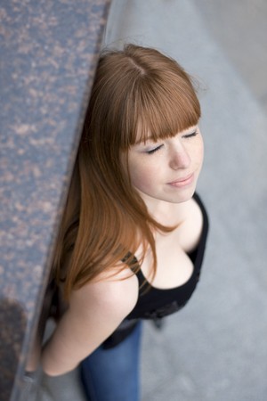Image of a girl with red hair, against the backdrop of the cityの写真素材