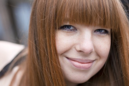 Image of a girl with red hair, against the backdrop of the cityの写真素材