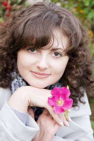 Picture of beautiful girl on a background of flowers and fruits dogroseの写真素材
