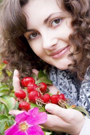 Picture of beautiful girl on a background of flowers and fruits dogroseの写真素材