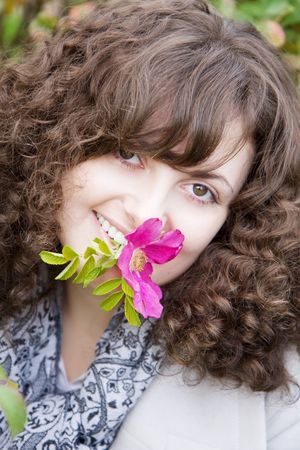 Picture of beautiful girl with a flower in your teeth dogroseの写真素材