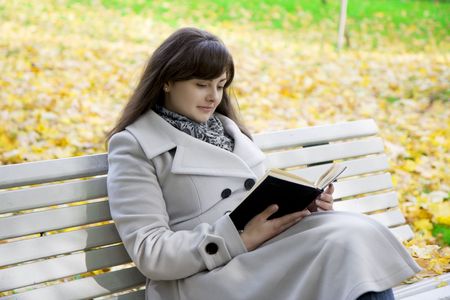 Picture of a girl who reads the book in the park on a benchの写真素材