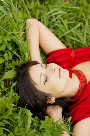 Picture of beautiful girl lying on the grass in the parkの写真素材