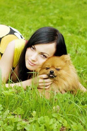 The image of a girl playing with a small dog in the parkの写真素材