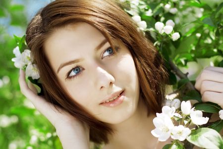 The image of the beautiful girl in the garden among the blooming treesの写真素材