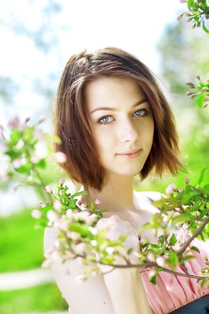 The image of the beautiful girl in the garden among the blooming treesの写真素材