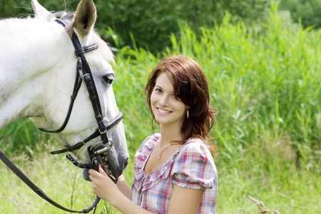 The image of a beautiful brunette girl with horseの写真素材